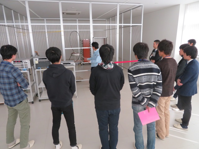 参加者も社員も立って、高圧電源の放電を見ている写真です。